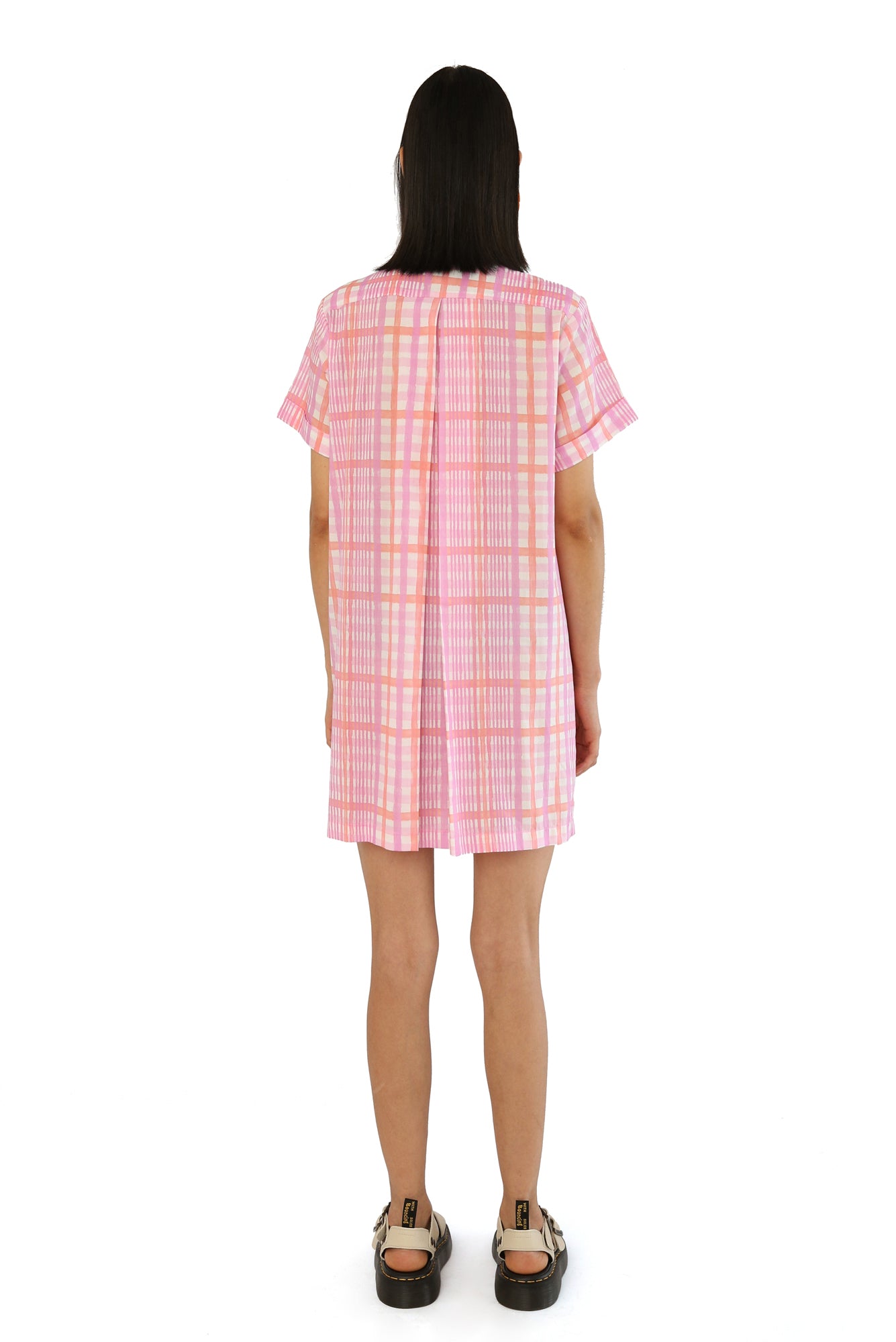 De Loreta Azulejo Dress in Loto print: Stylish mini pleated shirt dress in Loto print, featurinf a pink and lilac plaid pattern. A vibrant design with a comfortable fit. Made from high-quality cotton fabric, this versatile dress is perfect for casual and dressy occasions, offering a chic and modern look.
