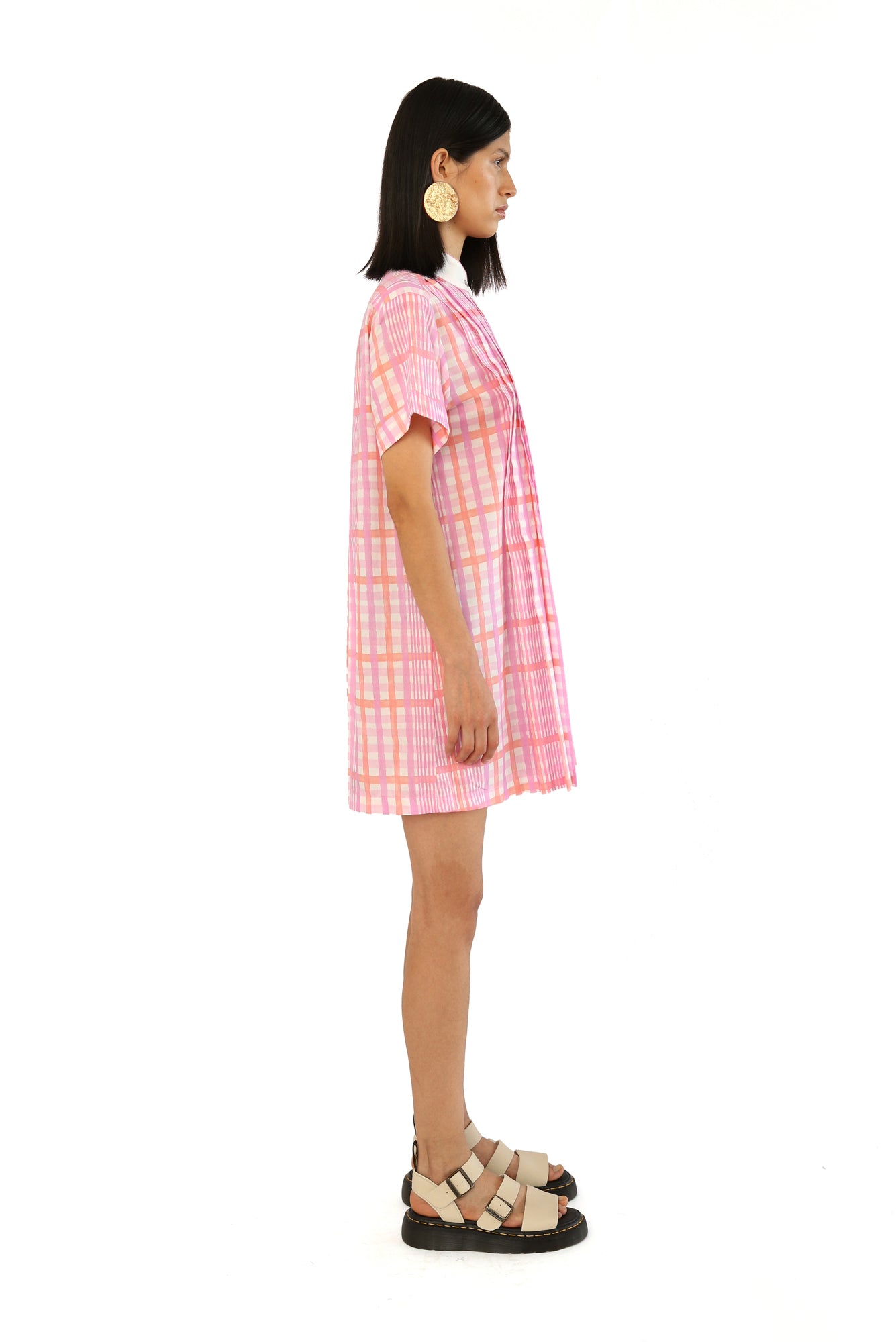 De Loreta Azulejo Dress in Loto print: Stylish mini pleated shirt dress in Loto print, featurinf a pink and lilac plaid pattern. A vibrant design with a comfortable fit. Made from high-quality cotton fabric, this versatile dress is perfect for casual and dressy occasions, offering a chic and modern look.