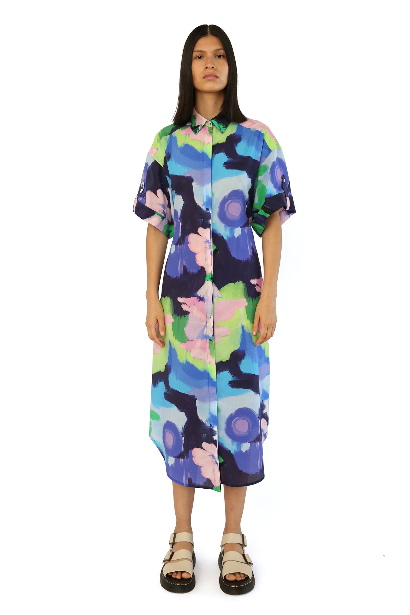 De Loreta Mari Dress in Oleo Azul print: Elegant midi shirt dress in Oleo Azul a blue, green and pink colored print, featuring a classic button-down design and a flattering silhouette. Made from high-quality fabric, this versatile dress is perfect for both casual and formal occasions, combining comfort with sophisticated style.