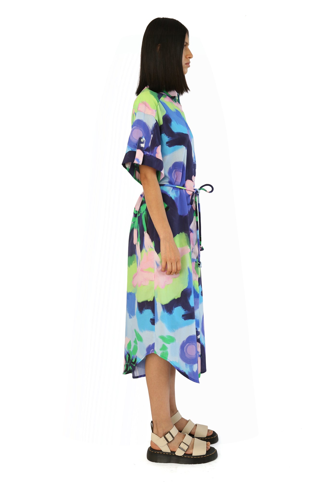 De Loreta Mari Dress in Oleo Azul print: Elegant midi shirt dress in Oleo Azul a blue, green and pink colored print, featuring a classic button-down design and a flattering silhouette. Made from high-quality fabric, this versatile dress is perfect for both casual and formal occasions, combining comfort with sophisticated style.