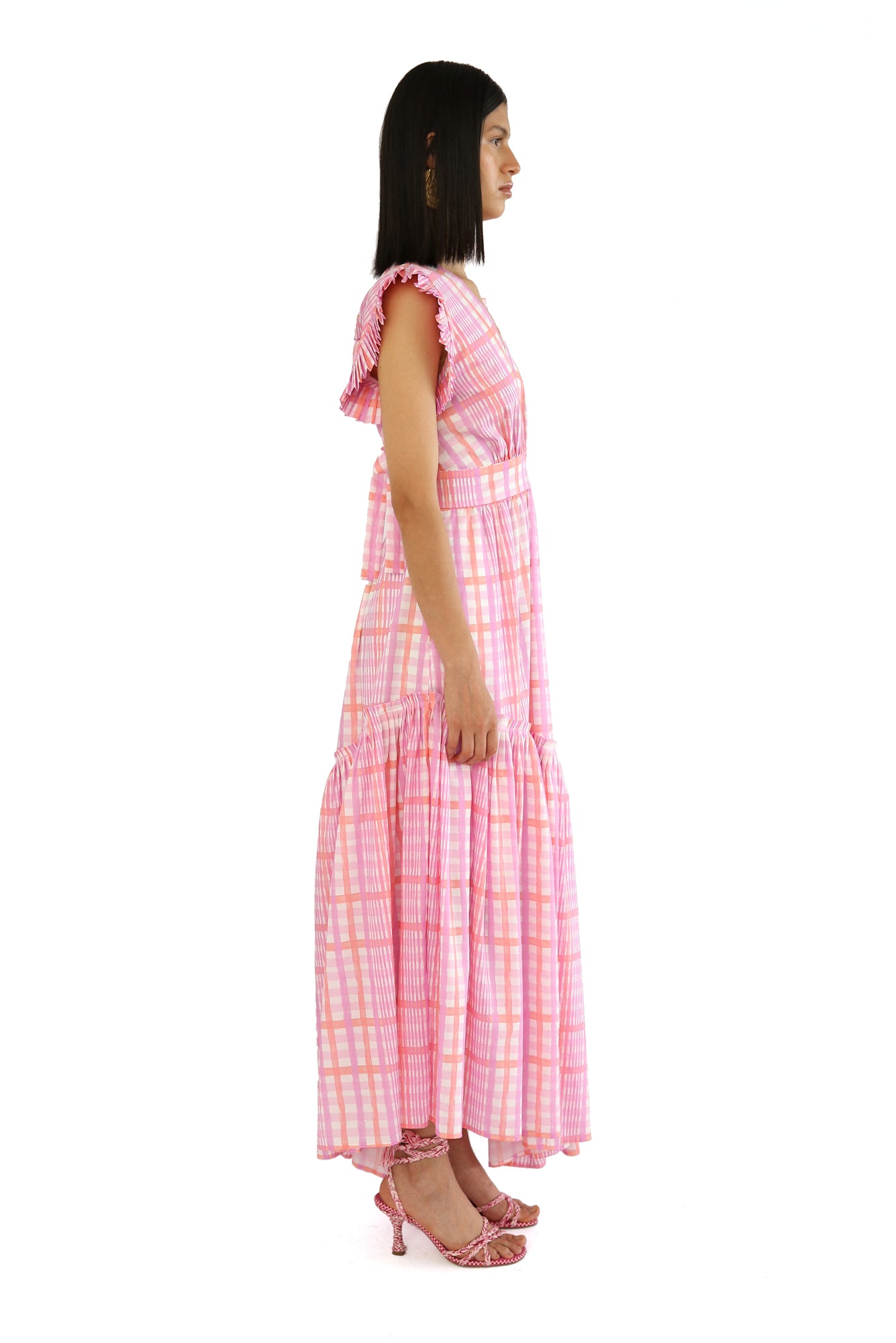 De Loreta Totora dress in Loto print: Featuring a vibrant pink and lilac plaid pattern with a flowy, asymmetric ankle-length silhouette. Designed with a flattering deep V-neckline, and a fitted bodice that flares into a breezy skirt. Crafted from soft, breathable fabric for comfort and style, perfect for summer events or casual outings